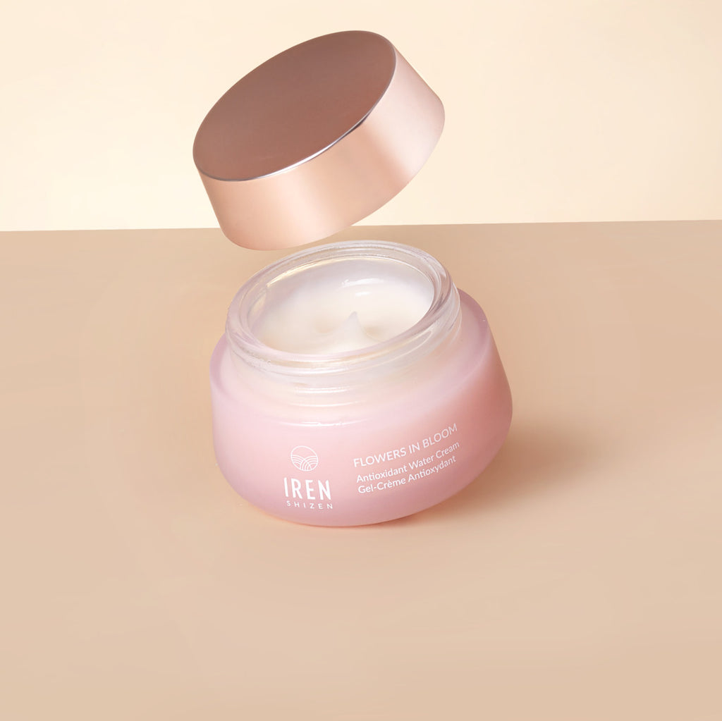 A jar of MOCHI SKIN Instant Glow Travel Set face cream by IREN Shizen with an open lid, revealing the instant glow cream inside, set against a soft beige background.