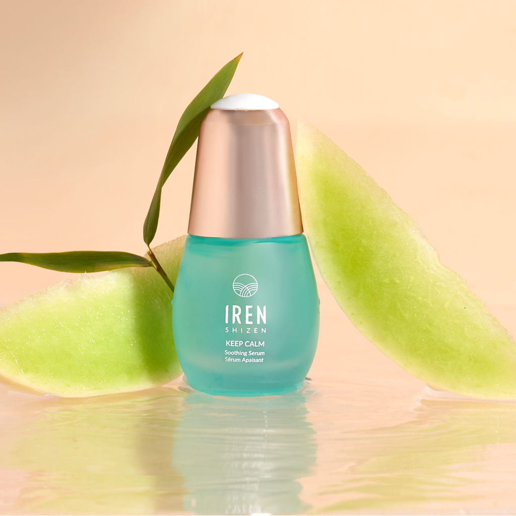 A bottle of IREN Shizen DEW UP PRO Skin Genie Pro + Hydrating Set with Japanese skincare and a slice of watermelon next to it.